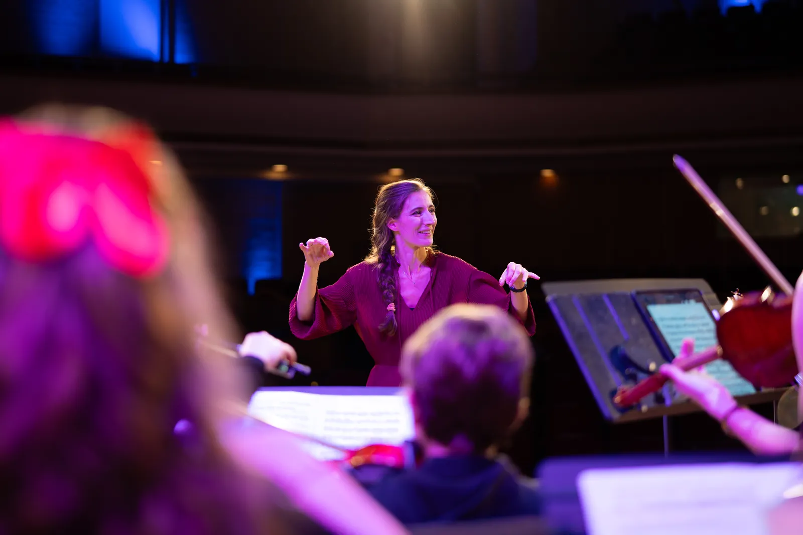 Maria conducting a youth orchestra on stage