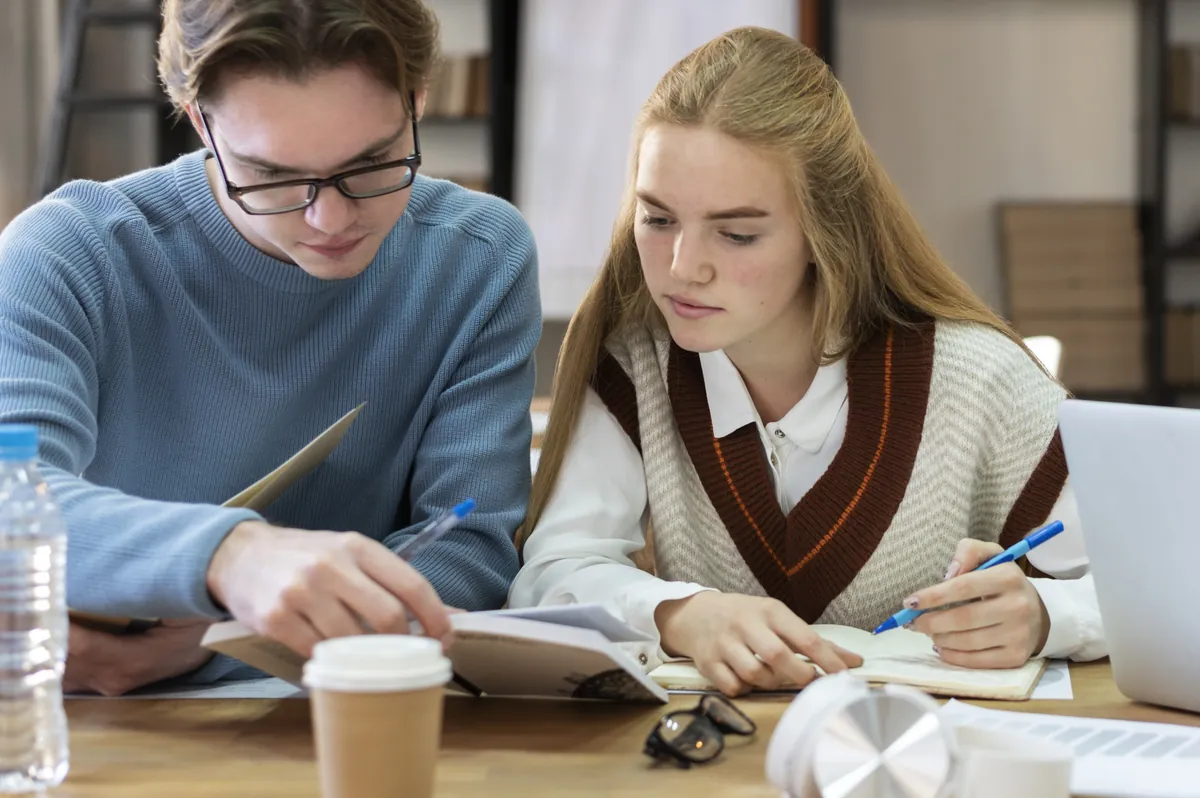 Two teenagers studying together at a table